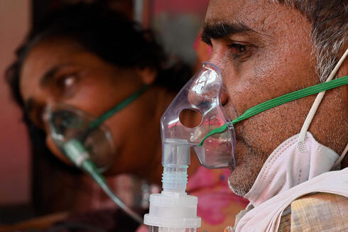 Pacientes enfermos de COVID-19 reciben oxígeno en India. 