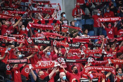 Aficionados del Hapoel Jerusaelm con máscaras de protección durante un partido de fútbol en Israel.