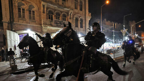 Policías montados a caballo intentan dispersar a los manifestantes durante la noche del sábado.