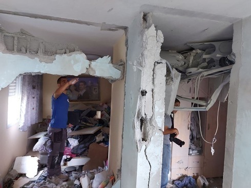 Un miembro de las fuerzas de seguridad inspecciona los daños causados en un edificio de Ashkelon que fue impactado por cohetes disparados desde Gaza.