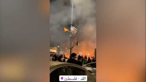 Manifestantes palestinos cambian una bandera israelí por una palestina en Lod.