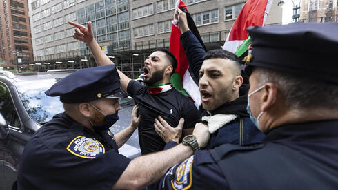Manifestante en favor de los palestinos es detenido por policías. 