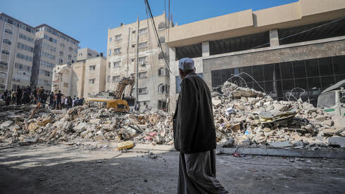 Un habitante de Gaza camina frente a un edificio destruido por las FDI.