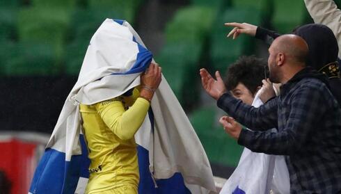 Tomer Hemed celebra su primer gol para Wellington Phoenix envuelto en la bandera israelí. 