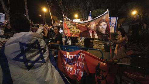 Manifestantes pro-Netanyahu sostienen carteles en los que comparan a los líderes de Yamina con terroristas por unirse a la coalición negociada por Lapid.