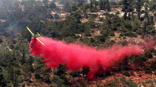 Un avión hidrante lucha contra las llamas en las colinas de Jerusalem.
