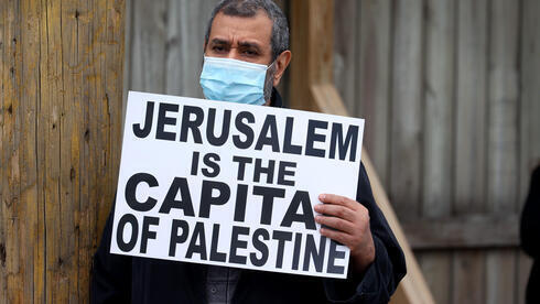 Un manifestante sostiene un cartel durante las protestas contra Israel en Illinois. 