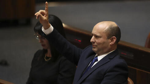 El primer ministro Naftalí Bennett vota para aprobar su nuevo gobierno en una sesión especial de la Knesset el domingo. 