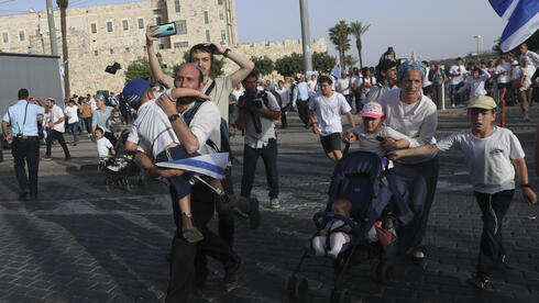 Los asistentes a la marcha corren a cubrirse mientras se disparan cohetes contra Jerusalem desde Gaza, el 10 de mayo de 2021. 
