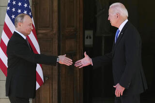 Biden y Putin se estrechan las manos. 