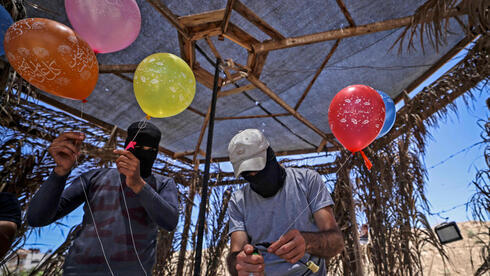 Palestinos preparan globos incendiarios para enviar a territorio israelí. 