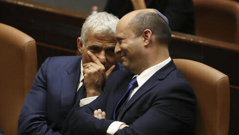 Yair Lapid y Naftali Bennett en la Knesset para la votación del domingo que los convirtió en canciller y primer ministro, respectivamente. 