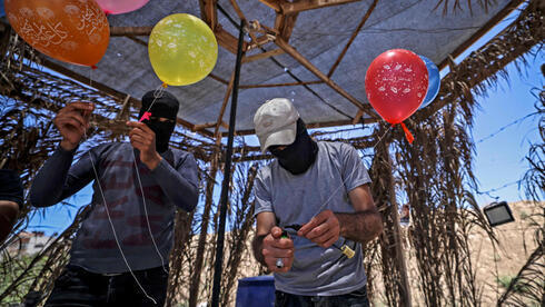 Miembros de la Yihad Islámica preparan globos incendiarios para lanzar hacia Israel. 
