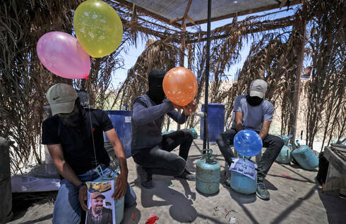 Miembros de la Yihad Islámica preparan globos incendiarios para enviarlos a Israel desde Gaza, el 15 de junio de 2021. 