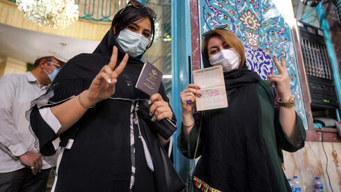Dos iraníes posan tras emitir sus votos. 