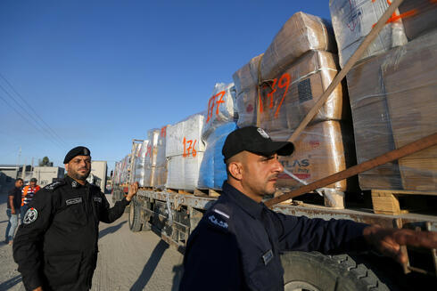 Policías palestinos junto a un camión que traslada ropa para exportación en el cruce Kerem Shalom.