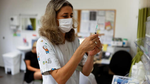 Una trabajadora médica se prepara para administrar una dosis de una vacuna contra el coronavirus. 