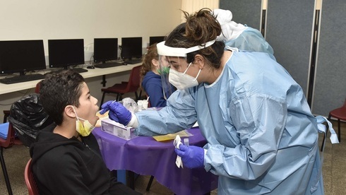 Una trabajadora de la salud realiza una prueba de coronavirus a un niño israelí.