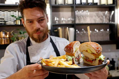 El chef israelí Shachar Yogev sirve una hamburguesa hecha con pollo cultivado. 