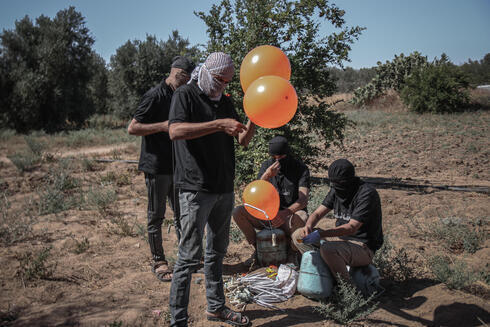 Fotos de la semana pasada, cuando terroristas preparaban globos explosivos para lanzar sobre Israel. 