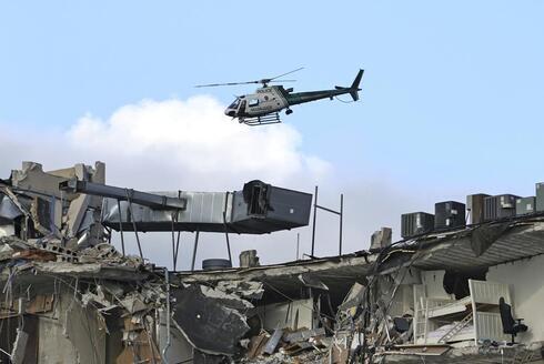 Un helicóptero de la policía de Miami-Dade sobrevuela el condominio Champlain Towers South. 