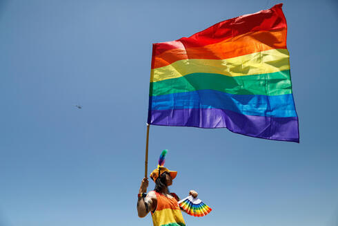 Una persona ondea una bandera gay en Tel Aviv.