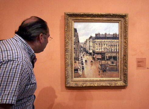 Un visitante observa en el cuadro impresionista titulado "Rue St.-Honore, Apres-Midi, Effet de Pluie", pintado en 1897 por Camille Pissarro, expuesto en el Museo Thyssen-Bornemisza de Madrid. 
