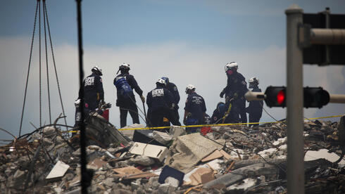 Equipos de rescate sobre la montaña de escombros del edificio colapsado. 