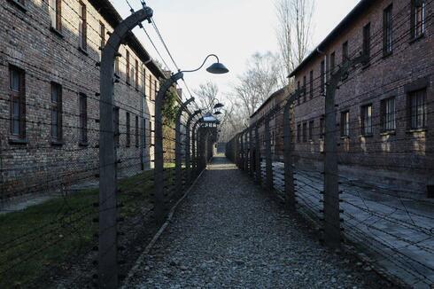 Un camino que conduce a una torre de observación y seguridad entre lo que fueron las vallas eléctricas de alambre de espino dentro del antiguo campo de exterminio nazi de Auschwitz I en Oswiecim, Polonia.