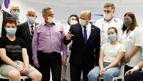 El primer ministro Naftali Bennett, a la derecha, y el ministro de Salud, Nitzan Horowitz, visitan un centro de vacunación en la ciudad central de Holon. 