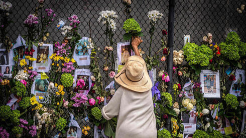 Una mujer deposita flores en homenaje a las víctimas en un memorial ubicado cerca de la escena de la tragedia.
