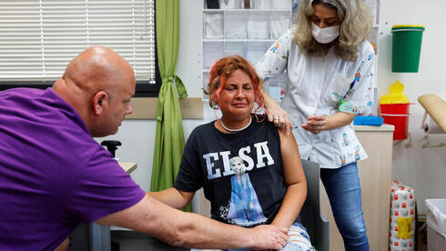 Un adolescente reacciona mientras recibe una dosis de la vacuna contra el coronavirus en una clínica de Tel Aviv. 
