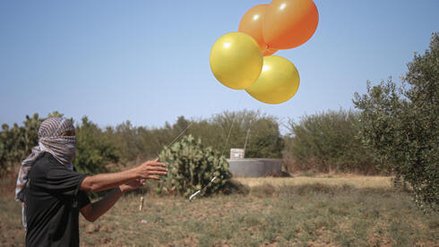 Palestinos se preparan para lanzar globos incendiarios contra Israel. 