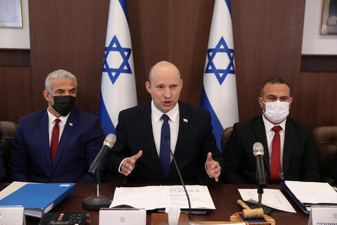 Bennett habla al comienzo de la reunión de gabinete el domingo acompañado por Yair Lapid (izq.), ministro de Relaciones Exteriores y Shalom Shlomo, secretario de Gabinete. 