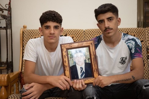Wassim y Yihad con la foto de su padre.
