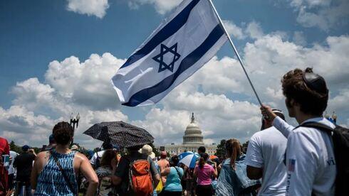 Un hombre sostiene una bandera israelí durante una protesta contra el antisemitismo en Washington.