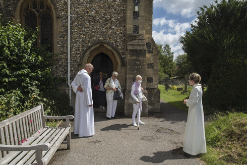 El reverendo Jonathan Gordon y la vicaria asistente Miranda Sheldon saludan a los fieles anglicanos en la iglesia de Santa María, Inglaterra. 