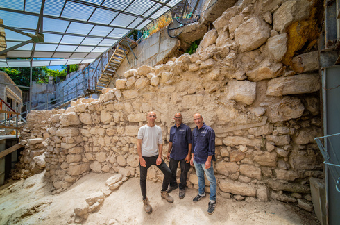 Directores de la excavación junto al segmento de muro encontrado. 