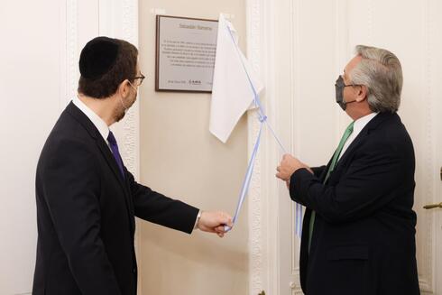El jefe de Estado argentino, Alberto Fernández, y el presidente de la AMIA, Ariel Eichbaum, descubren una placa en homenaje a la víctima más joven del atentado contra la entidad judía.