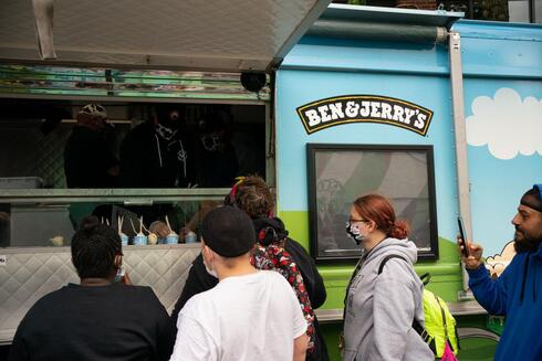 La gente hace cola para obtener muestras de helado de Ben &amp; Jerry's. 