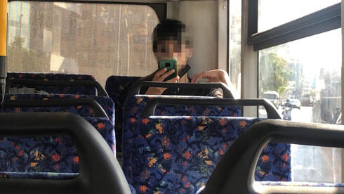 Un pasajero viaja en autobús sin el barbijo puesto, a pesar de la obligación de usarlo. 