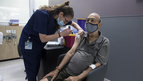 Un anciano recibiendo la vacuna COVID en el Centro Médico Sheba.