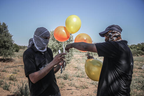 Miembros de Hamás lanzan globos incendiarios desde la Franja de Gaza hacia Israel. 