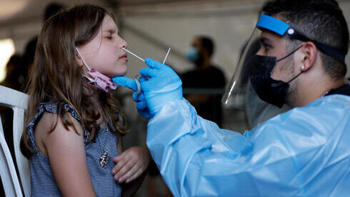Una niña es sometida a una prueba de detección de coronavirus en un centro de salud de Tel Aviv. 