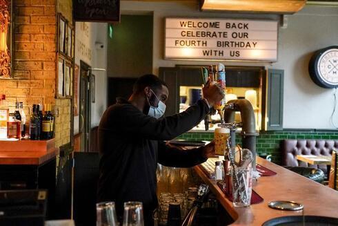 Un camarero sirve una pinta de cerveza en el pub Prince of Peckham, que reabre a los clientes de interior, en Londres. 
