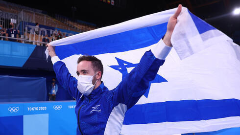 El gimnasta artístico Artem Dolgopyat sostiene la bandera de Israel después de ganar una medalla de oro en los Juegos de Tokio el domingo. 