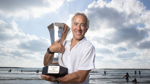 Sylvan Adams sostiene el trofeo de la Supercopa de Francia en la playa de Tel Aviv. 