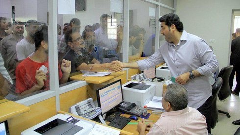 Funcionarios desembolsan el dinero de la ayuda catarí a los civiles de Gaza en un banco postal local. 