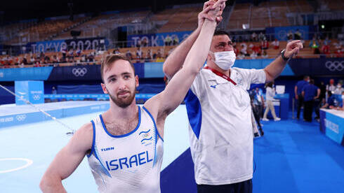Dolgopyat celebra su medalla de oro en el ejercicio de suelo junto al fisioterapeuta del equipo nacional. 