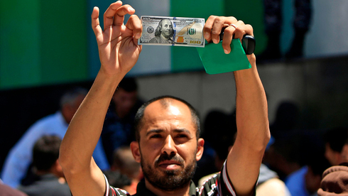 Un ciudadano palestino muestra el dinero entregado como parte de la ayuda de Catar a Gaza. 